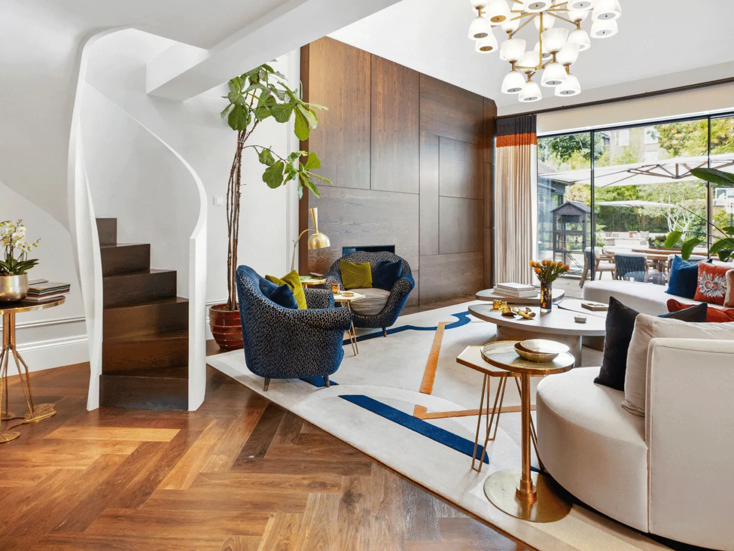 A drawing room with parquet floors and a sculptural staircase